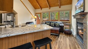 A kitchen with a marble countertop, wooden cabinets, and a built-in stove. - Quiet Fall River Suite • Fireplace • Close to RMNP (Estes Park)