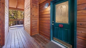 A wooden exterior with a green door marked '20' and a balcony with a railing. - Riverside Sanctuary • RMNP • River Views (Estes Park)