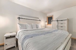 A bedroom with a bed, bedside tables, a wardrobe, and a window.