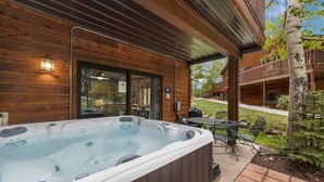 A wooden cabin with a hot tub, outdoor seating, and a covered patio. - Fall River Retreat • Private Hot Tub • Close to RMNP (Estes Park)