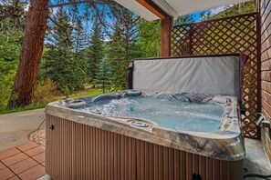 A hot tub in an outdoor setting with a wooden deck and a lattice fence.