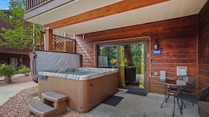 A wooden cabin with a hot tub, outdoor seating, and a door marked 'B16'.