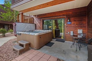 A wooden cabin with a hot tub, outdoor seating, and a door marked 'B16'.