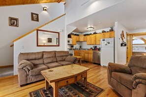A cozy living room with a sofa, a wooden coffee table, and a patterned rug. - Riverfront Hideaway • Private Hot Tub • Near RMNP (Estes Park)
