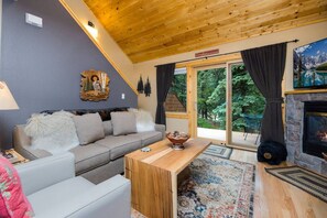 Un salon chaleureux avec un canapé, une table basse en bois et une cheminée.