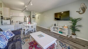 A modern living room with a sofa, coffee table, and a TV mounted on the wall.