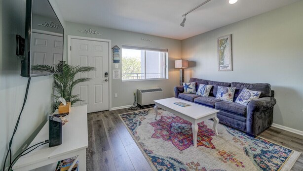 A living room with a sofa, coffee table, and a large window.