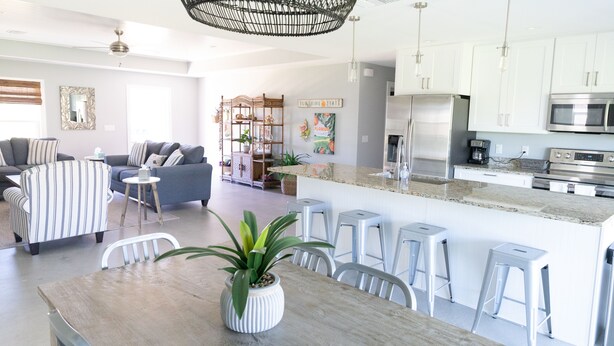 A modern kitchen with white cabinets, a stainless steel refrigerator, and a built-in microwave. - Family Retreat South Spacious 4BR, 4BA Getaway (Sebastian)