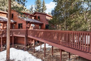 Eine Holzhütte mit überdachter Veranda und verschneitem Grund.