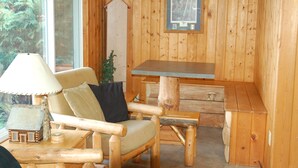 A wooden cabin interior with a sofa, a small table, and a bench. - Welcome to Lakeview Pine: The Lakeside Escape (Birchwood)
