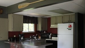 Cocina compacta equipada con refrigerador, microondas, estufa y lavaplatos.