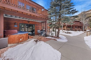 A wooden building with a hot tub, outdoor seating, and a snow-covered ground. - Fall River Hideaway • Private Hot Tub (Estes Park)