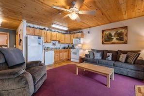 A cozy living room with a grey sofa, a wooden coffee table, and a ceiling fan. - Fall River Hideaway • Private Hot Tub (Estes Park)