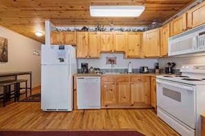 A kitchen with wooden cabinets, a refrigerator, a dishwasher, a stove, and a microwave.