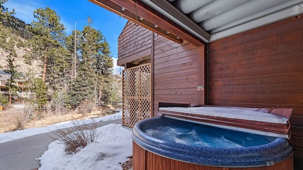 A wooden hot tub with a wooden deck, surrounded by a wooden fence and a snow-covered ground. - Fall River Hideaway • Private Hot Tub (Estes Park)