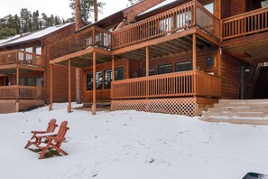 A wooden cabin with multiple balconies and a covered porch area.