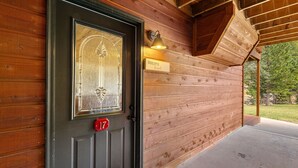 Une cabane en bois avec une porte sombre, une pancarte indiquant « Bienvenue » et le numéro 17 sur la porte.
