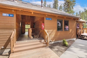 A wooden cabin with a porch, a staircase, and a mailbox.