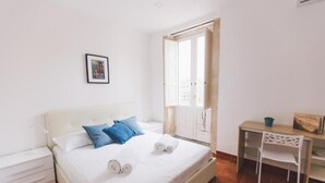 Ein Schlafzimmer mit einem Bett, einem Schreibtisch und einem Sessel.