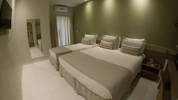 Une chambre d’hôtel avec deux lits, un téléviseur à écran plat, une table de chevet et un miroir.