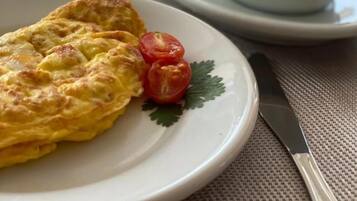 Un plat amb una truita, una tassa de cafè i una ampolla d'aigua sobre una taula.