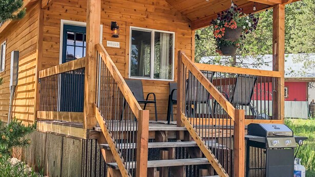 A wooden cabin with a porch, a staircase, and a grill outside. - SUPER CUTE & CLEAN MODERN HOME 40 min. to YNP (Island Park)