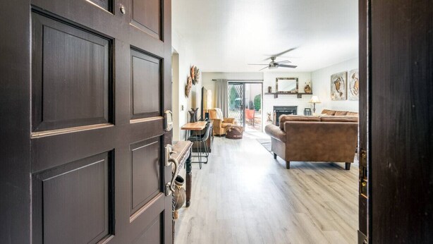 A spacious living room with a fireplace, a sofa, and a dining area with chairs.