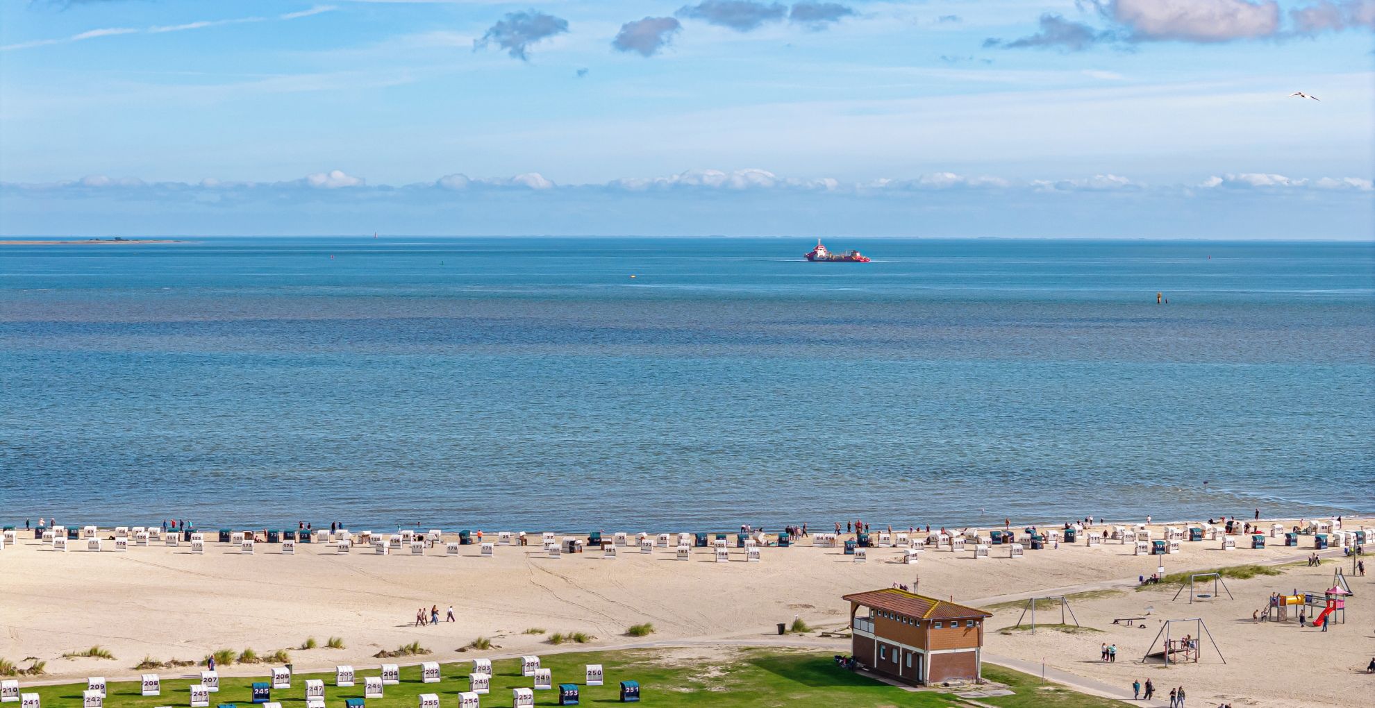 A beach with numbered beach chairs and a lifeguard tower.
