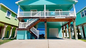 Ein zweistöckiges Haus mit Balkon, Veranda und Garage.