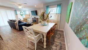 Un comedor con una mesa y sillas de madera, un sofá y un televisor al fondo.