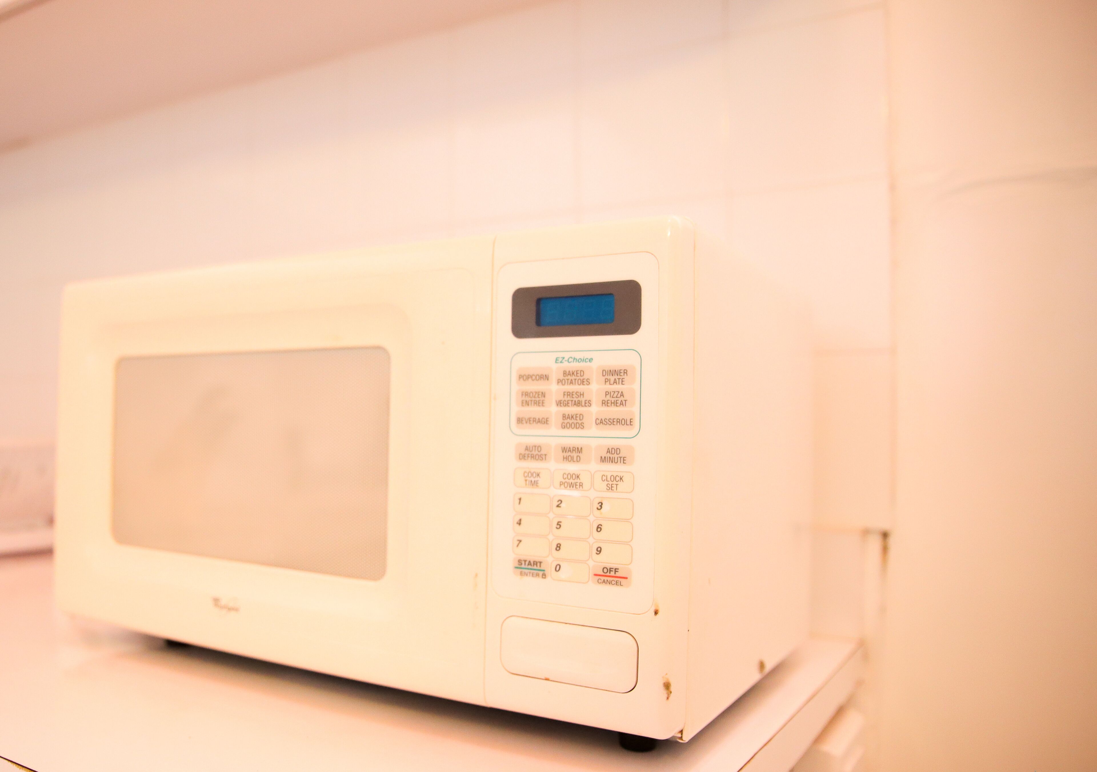 Un forno a microonde bianco con display digitale e tastierino.