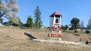 Un parque con una torre de vigilancia roja y blanca.