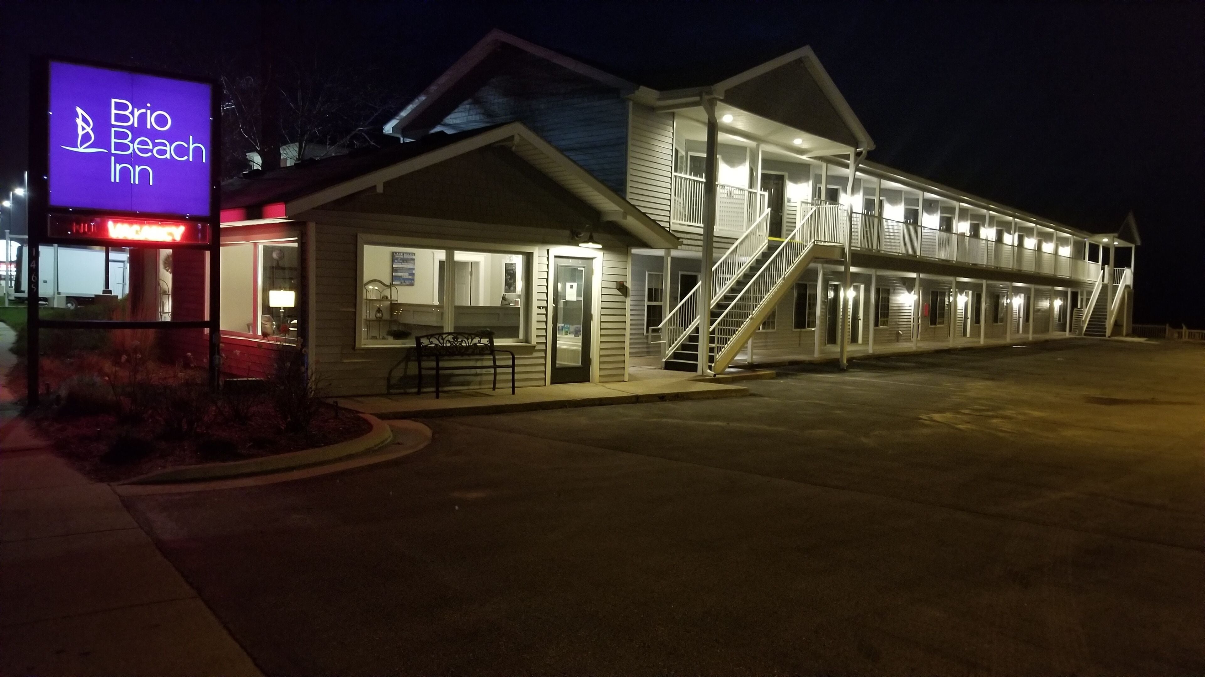 Un motel con un cartel que dice "Brio Beach Inn" de noche.