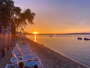 A beach with lounge chairs and a sunset over the water. - Brio Beach Inn (Traverse City)