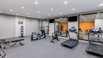 A gym with treadmills, stationary bikes, and weight machines.
