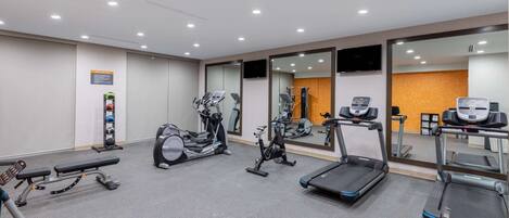 A gym with treadmills, stationary bikes, and weight machines.