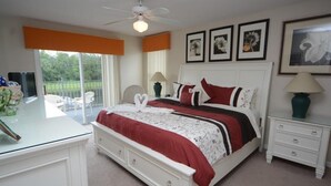 A bedroom with a bed, white nightstands, a desk, and a ceiling fan. - Ref 36 5 Bed Villa With own Pool Near Disney (Kissimmee)