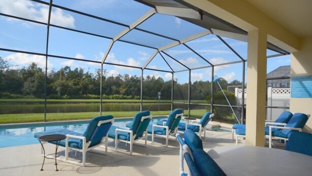 A covered outdoor area with a pool, lounge chairs, and a table. - Ref 36 5 Bed Villa With own Pool Near Disney (Kissimmee)