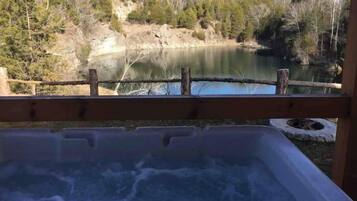 A hot tub with a view of a lake and forest.