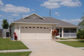 A single-story house with a garage, a covered porch, and a well-maintained lawn. - Ref 20 3 bed Home With Private Pool Pet Friendly (Kissimmee)