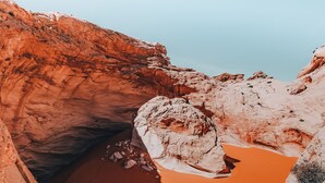 A large rock formation with a deep crevice and a small pool of water. - Wander Camp Bryce Canyon - Escalante (Cannonville)