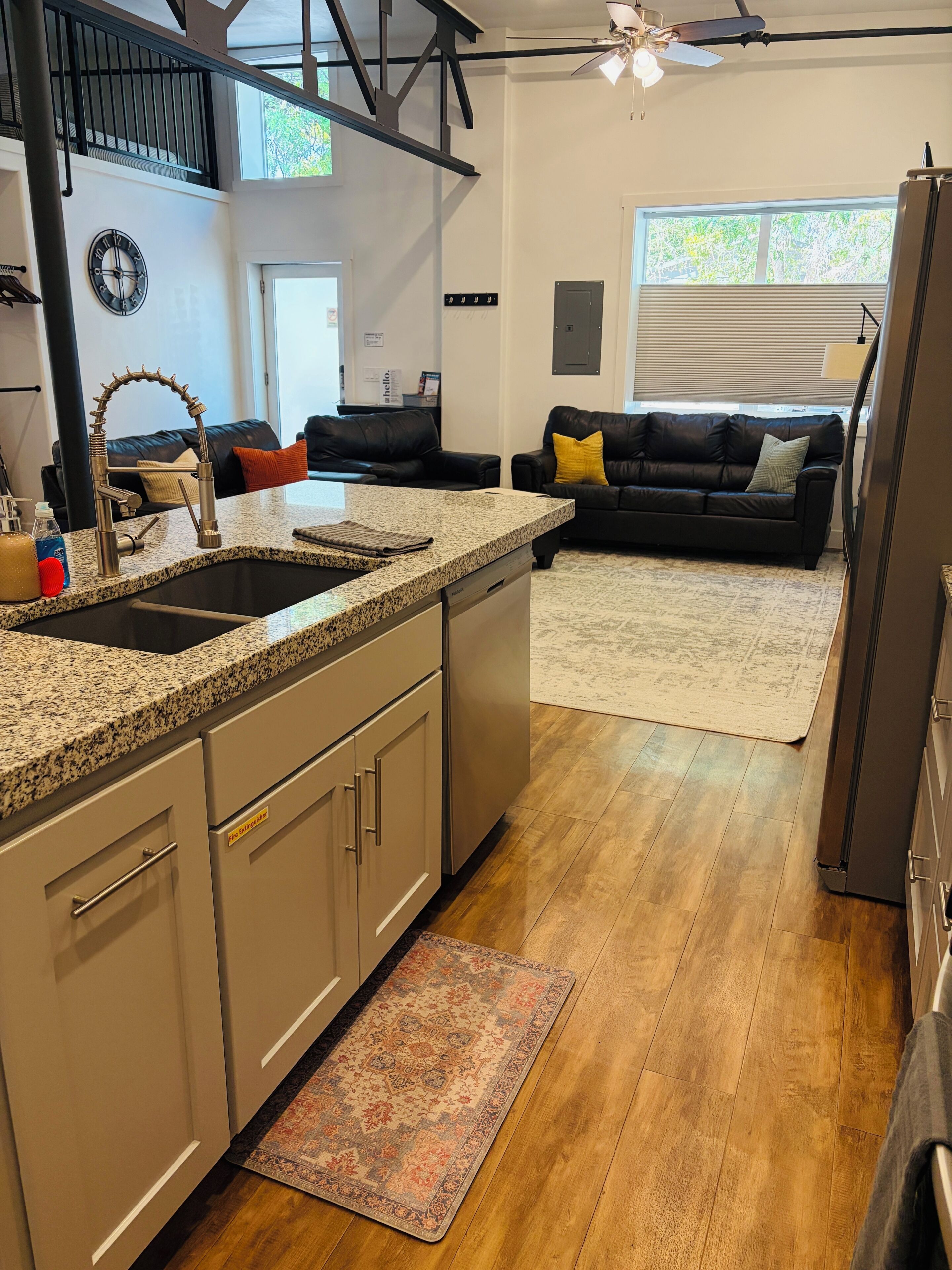 A modern kitchen with granite countertops, stainless steel appliances, and a built-in dishwasher.