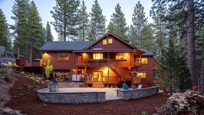 A two-story lodge with a stone retaining wall, a covered deck, and a fire pit. - 2 Blocks to Lake Tahoe! Group Gem w/ Hot Tub (Incline Village)
