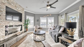 Relax in this stylish living room with a fireplace, flat-screen TV, and comfortable sofa.