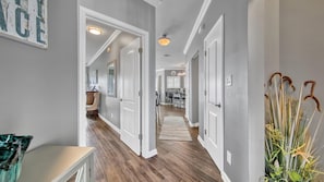 Stunning hallway with light gray walls, dark wood flooring, and a classic white door design.