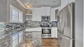 Enjoy cooking in this well-equipped kitchen with a refrigerator, oven, and ample countertops.