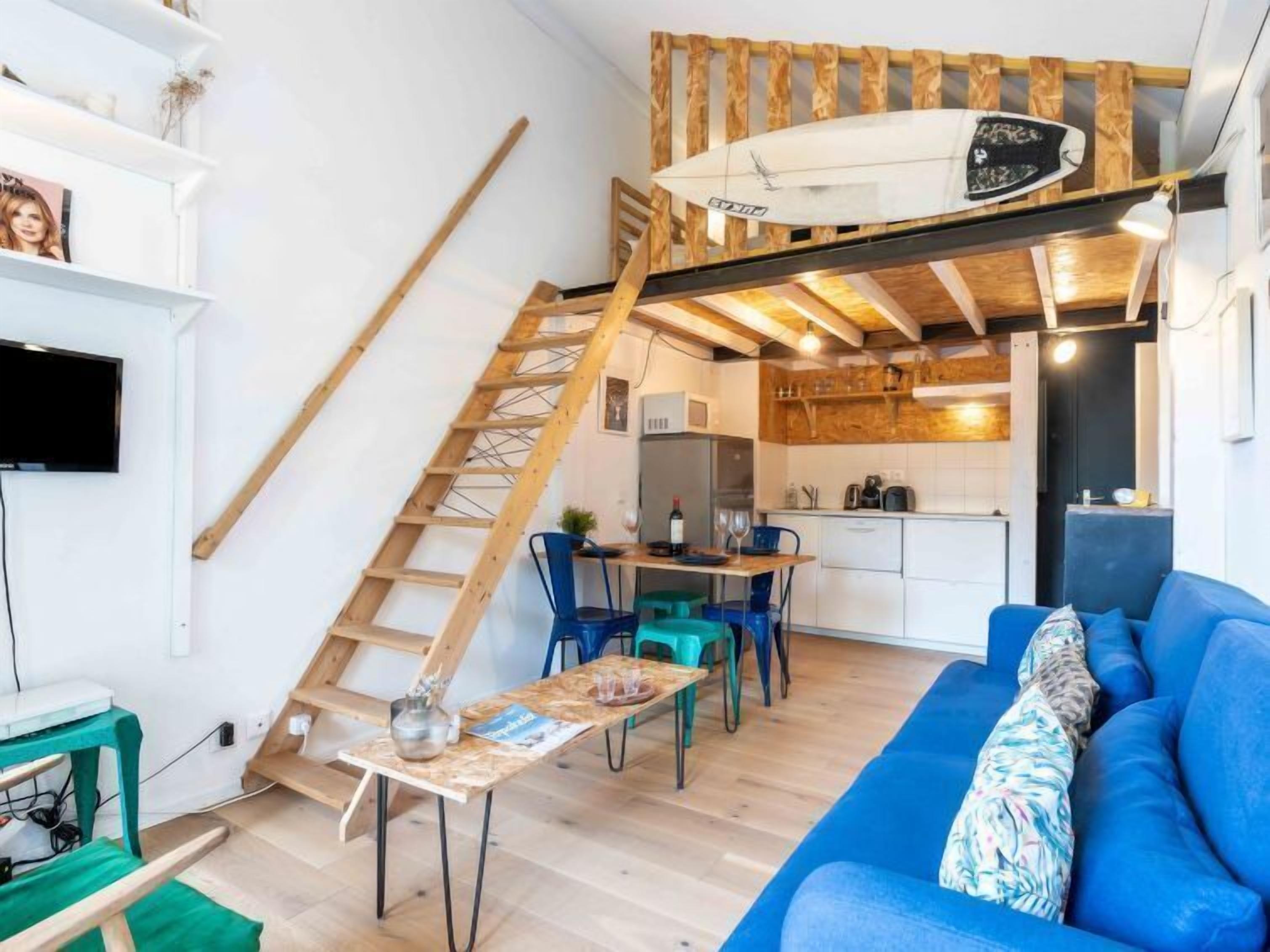 Un espace de vie compact comprenant une mezzanine, un coin repas et une cuisine.