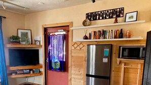A compact kitchen with a refrigerator, microwave, and wooden cabinets.