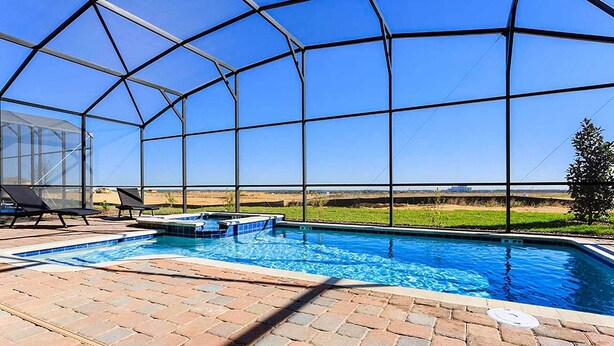 A swimming pool with a glass enclosure, lounge chairs, and a view of the landscape. - Private 5-Star Pool Escape, Orlando Villa 4304 (Orlando)