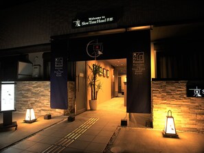 The entrance to Slow Time Hotel Kyoto with a welcoming sign, a potted plant, and two illuminated lanterns. - SlowTime Hotel Kyoto (Kyoto)